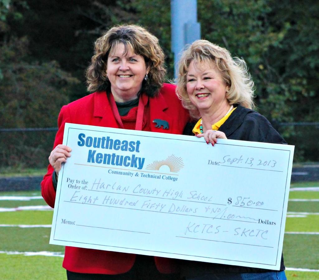 Southeast Kentucky Community and Technical College President Dr. Lynn Moore (right) presented a check to Harlan County HIgh School Principal Edna Burkhart before the Knox Central-Harlan County football game at Coal Miners Memorial Stadium.
