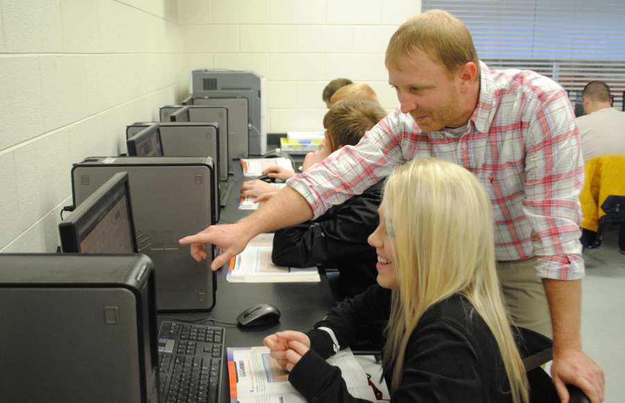 Harlan County High School web design instructor Scott Pace worked with Abby Landis on a project during a class. The HCHS program allows students to create web pages for area businesses and organizations.